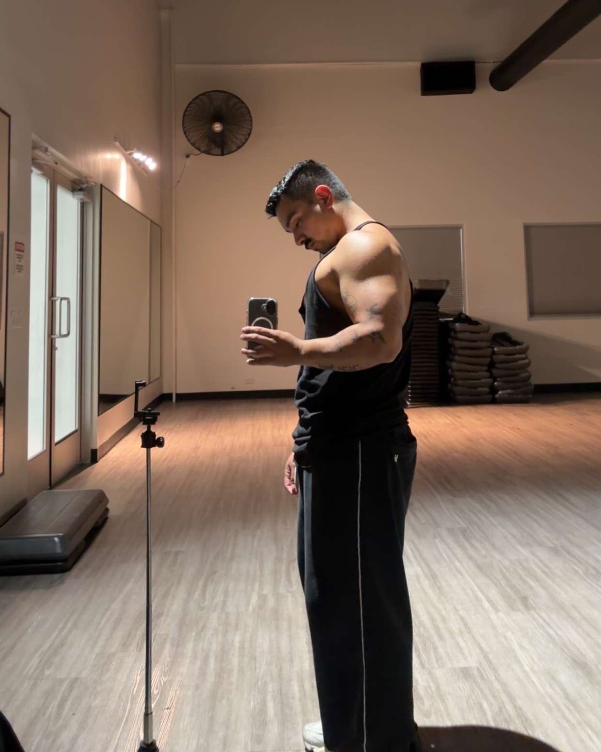 Dominic Alvarez in a mirror photo in a studio, phone in hand